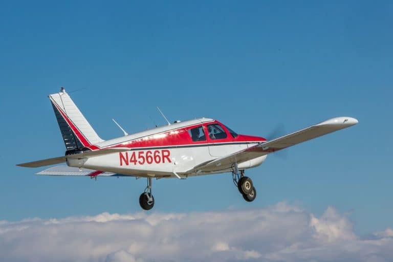 A Piper Cherokee in flight, with a flight instructor and student pilot - Why Are Fewer People Pursuing a Pilot License?