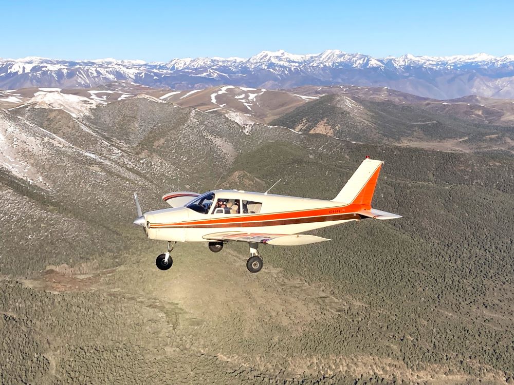 Piper Cherokee 180 flying over the Sierras
